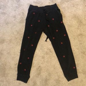 Black fuzzy pink sweatpants with red roses